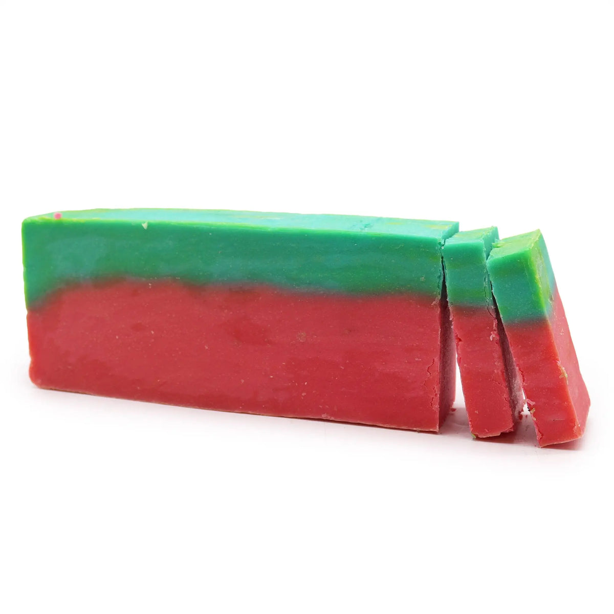Barra de jabón artesanal bicolor, con base roja y capa superior verde, sobre fondo blanco, parcialmente rebanada.