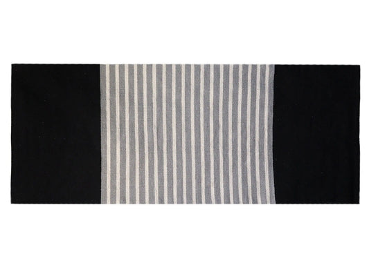 Alfombra rectangular de algodón, diseño a rayas gris y blanco en el centro y bordes laterales negros sólidos.