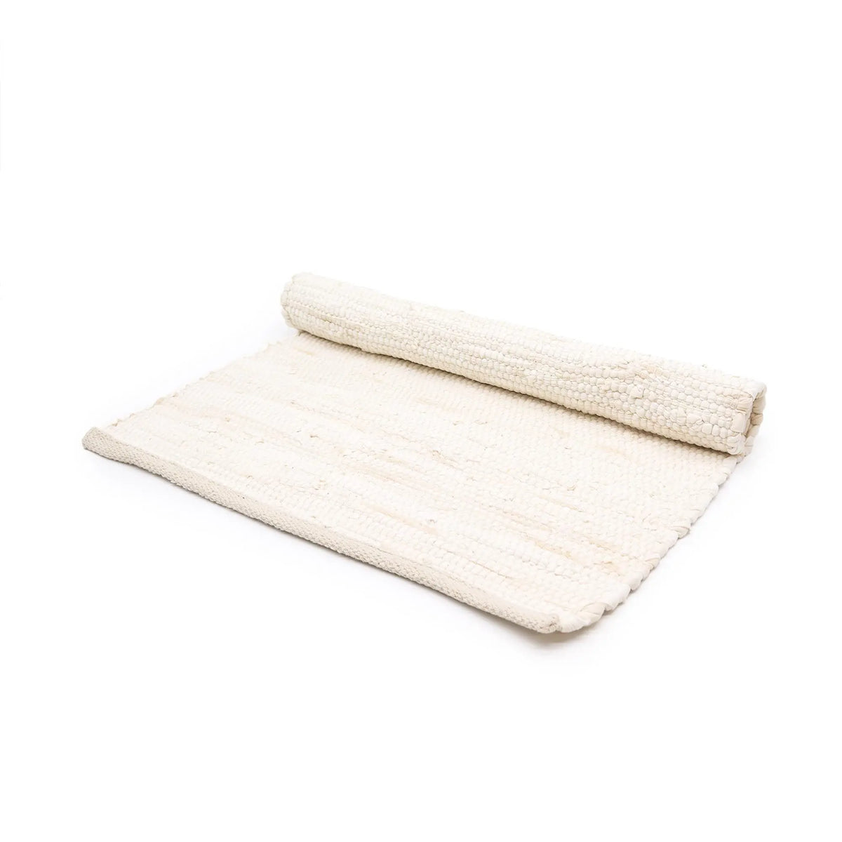 Alfombra pequeña de algodón color crema, tejida a mano, rectangular y parcialmente enrollada sobre fondo blanco.