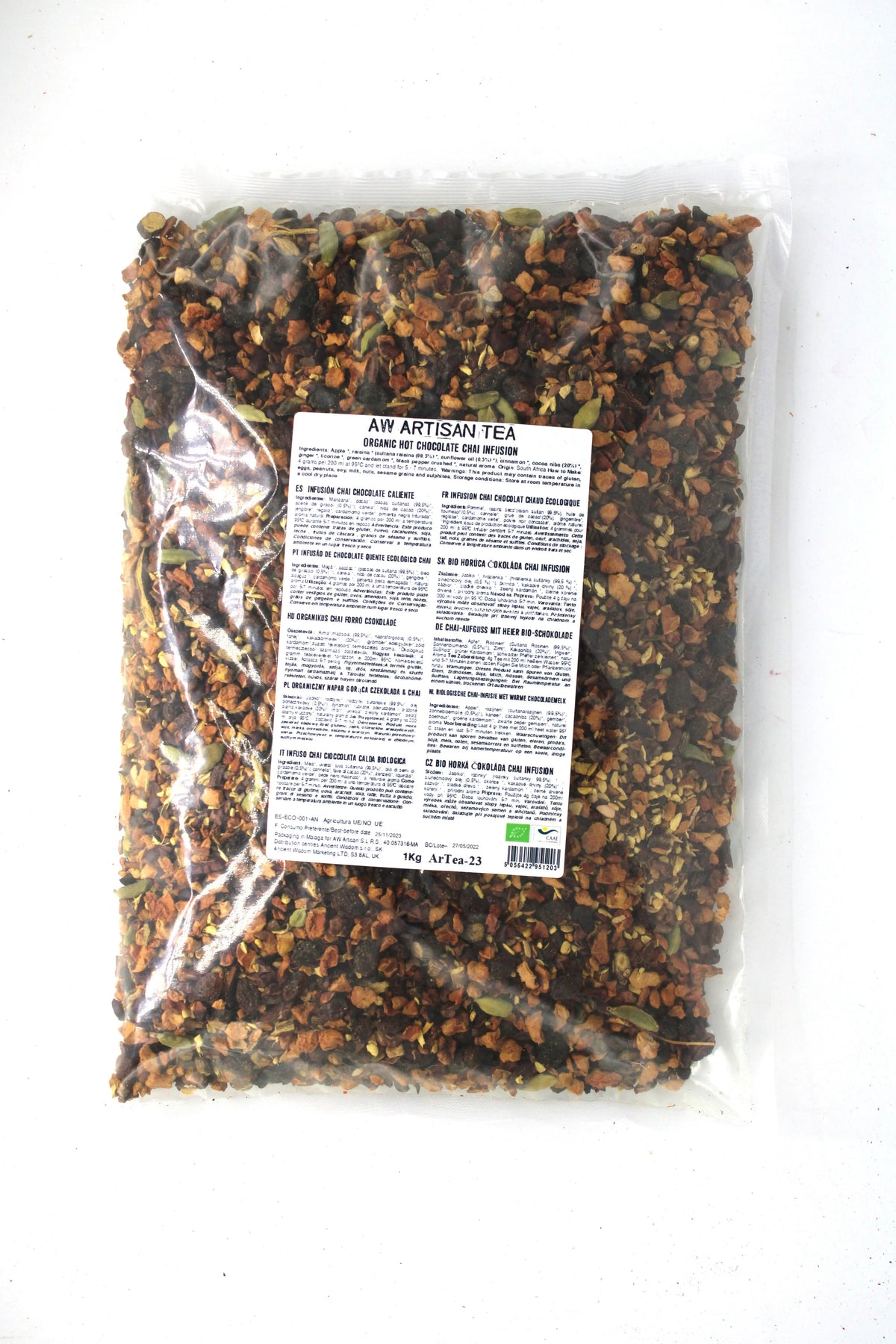Bolsa de plástico transparente de 1kg con mezcla de trozos de té chai, chocolate y especias, con etiqueta informativa.