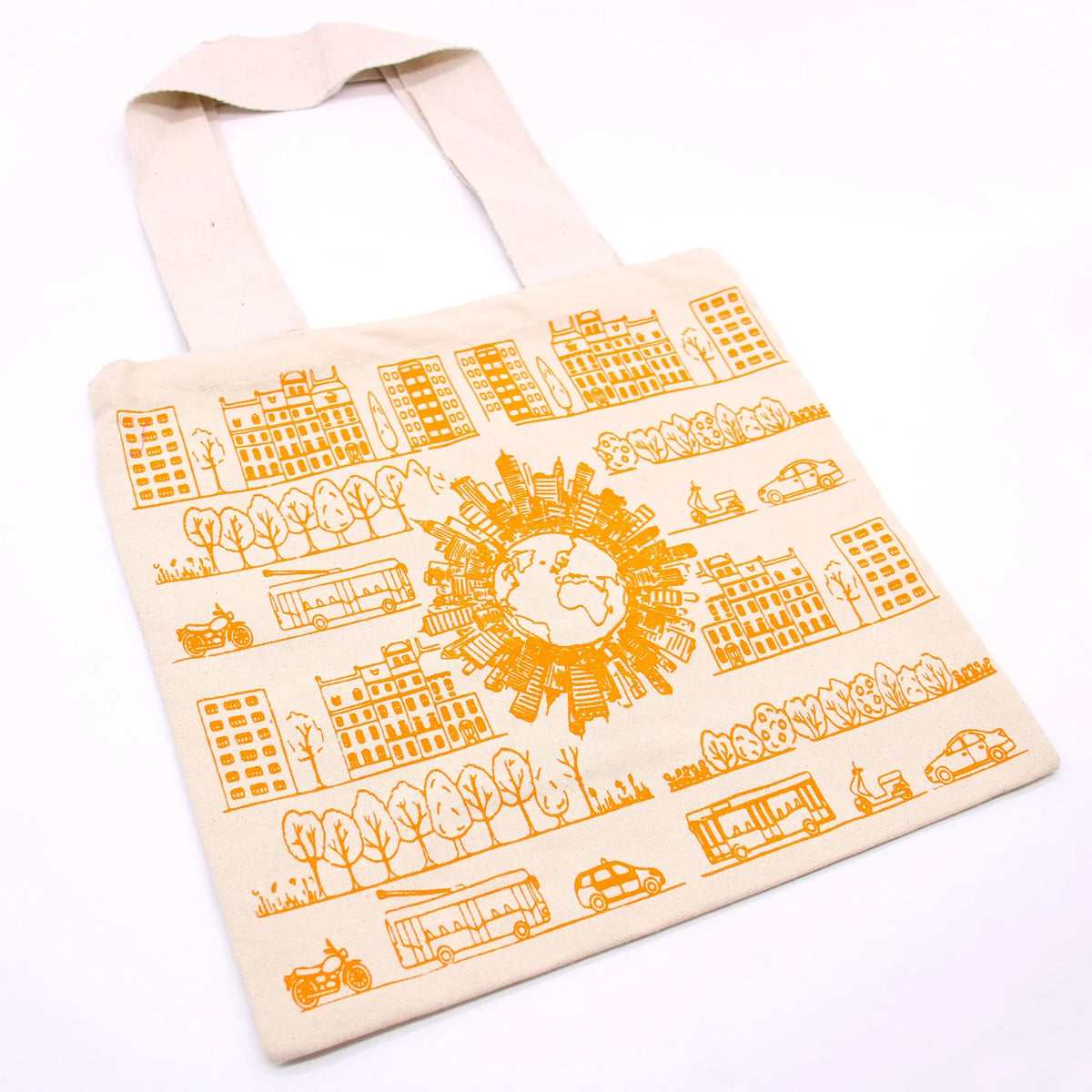 Bolsa de tela color crema con estampado en naranja de edificios, vehículos y un globo terráqueo estilo urbano.