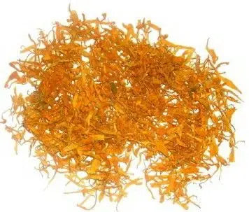 Montón de pétalos de caléndula secos de color naranja intenso, dispuestos sobre un fondo blanco neutro.