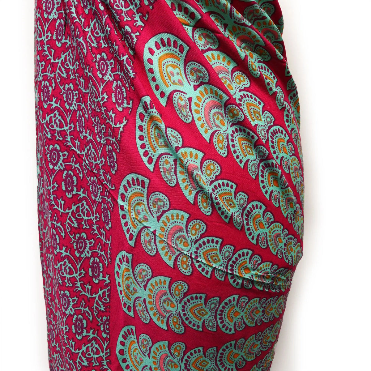 Pareo de tela ligera con estampado de mandala en tonos fucsia, verde azulado y naranja sobre fondo morado intenso