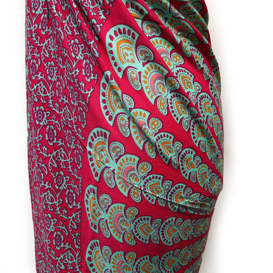 Pareo de tela ligera con estampado de mandala en tonos fucsia, verde azulado y naranja sobre fondo morado intenso