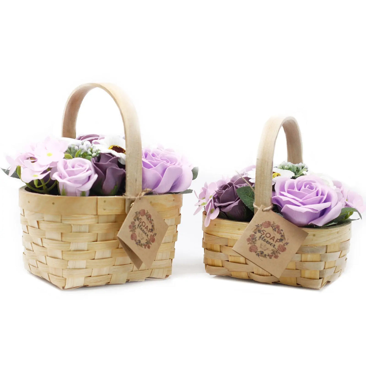 Dos canastas de mimbre claro con ramos de rosas y flores de jabón en tonos lilas y violetas sobre fondo blanco.