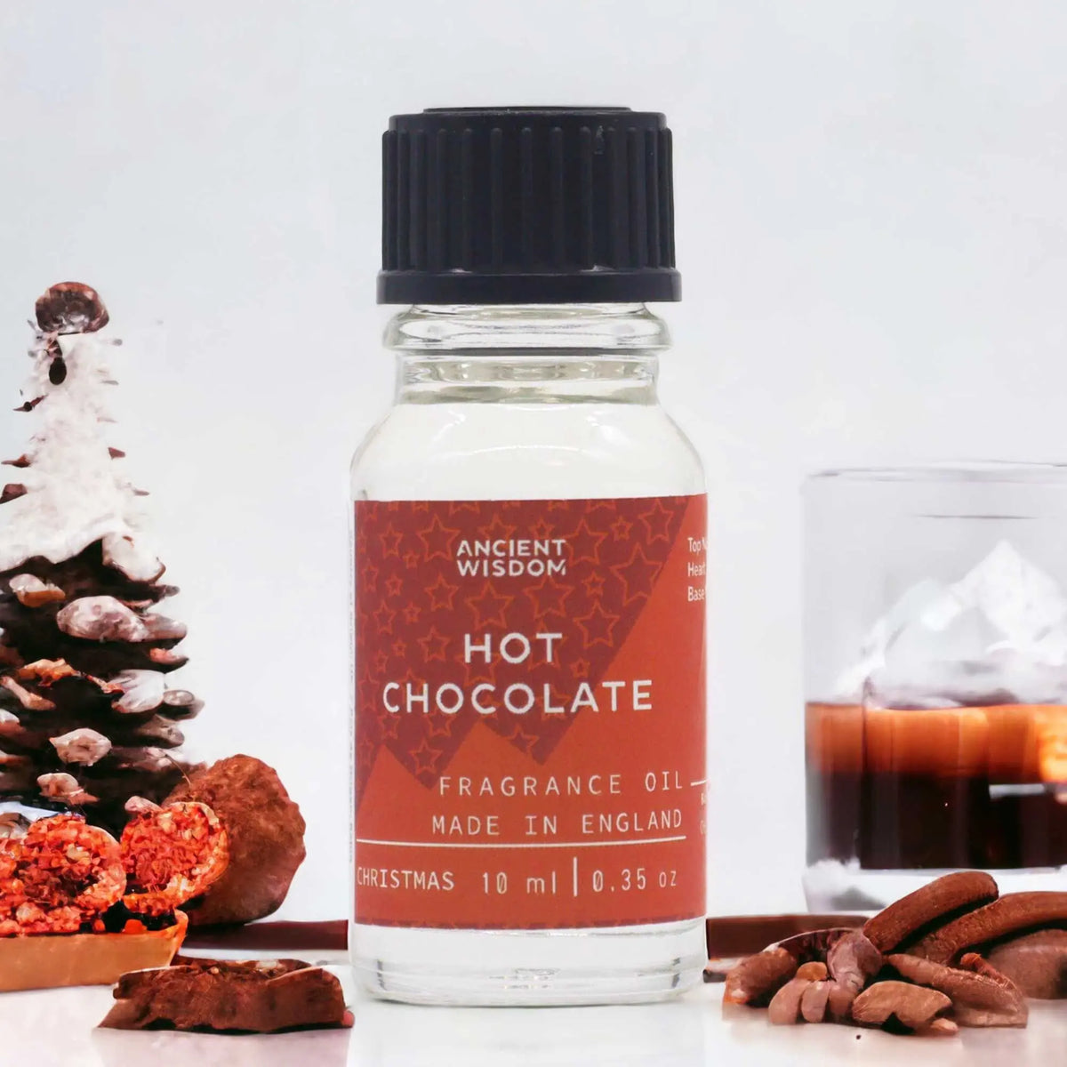 Frasco de 10ml de aceite de chocolate con etiqueta roja, junto a una piña nevada y trozos de chocolate sobre fondo blanco.