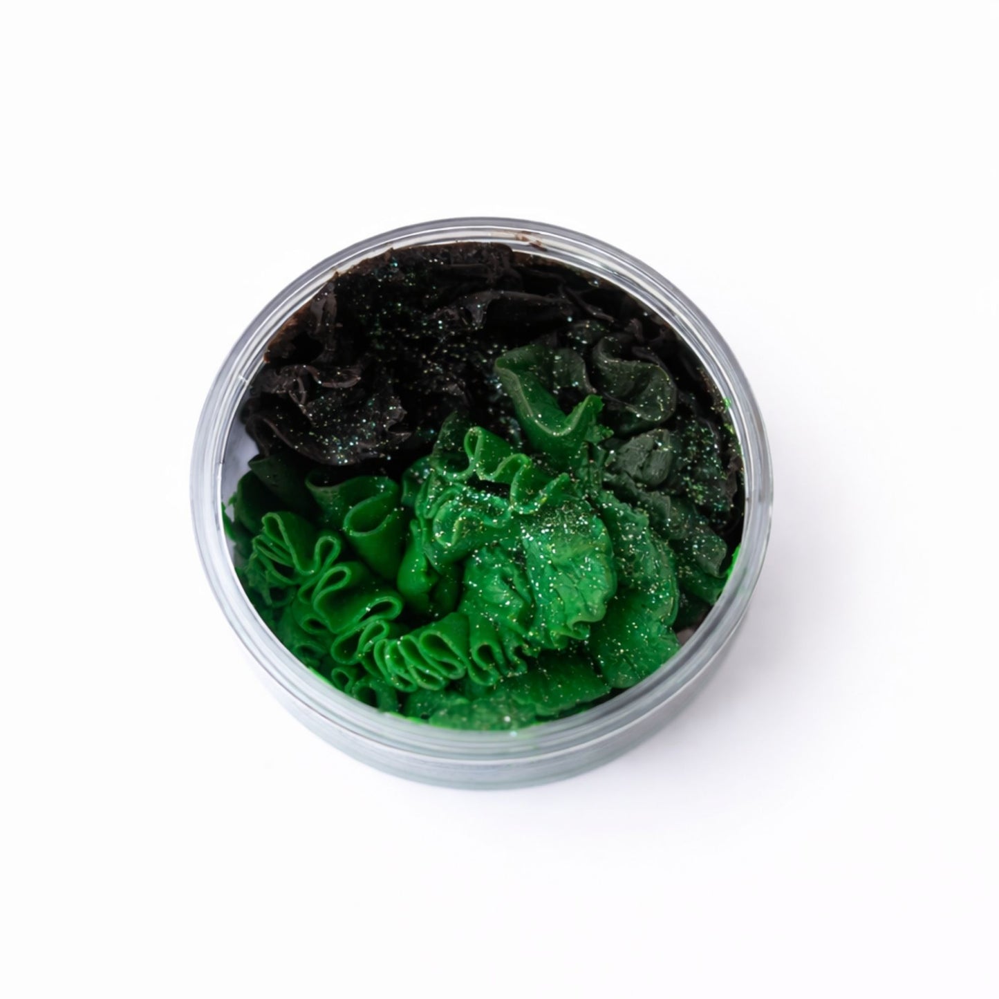 Pasta de modelado verde brillante y negra en envase transparente, ideal para manualidades y decoraciones creativas.