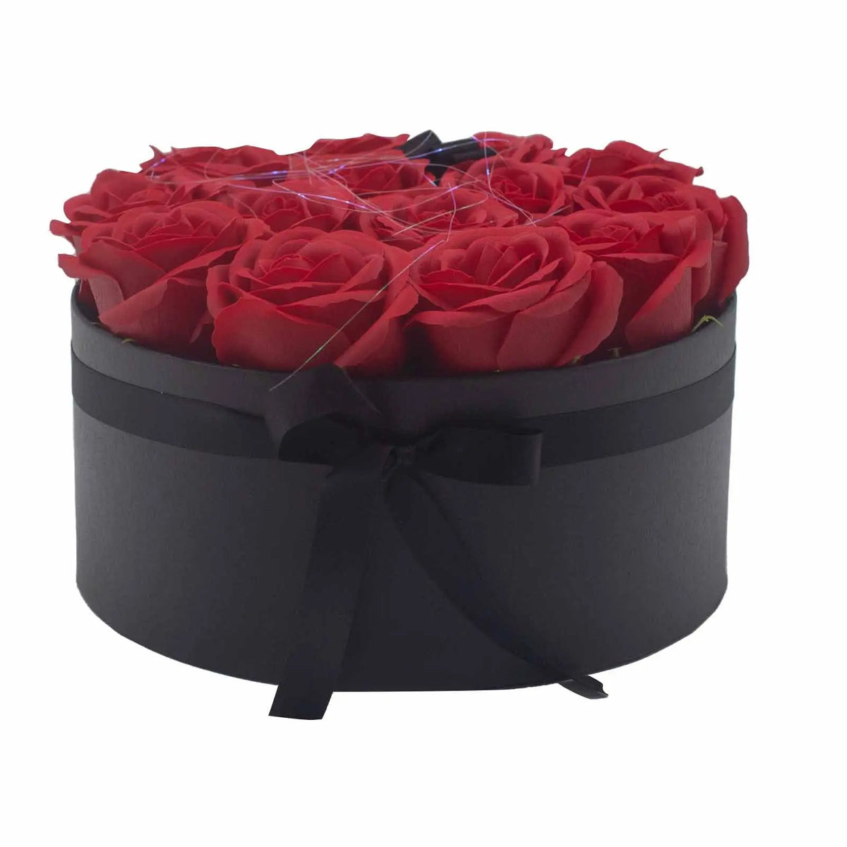 Caja redonda negra con 14 rosas rojas de jabón y un elegante lazo negro de cinta en la parte frontal.