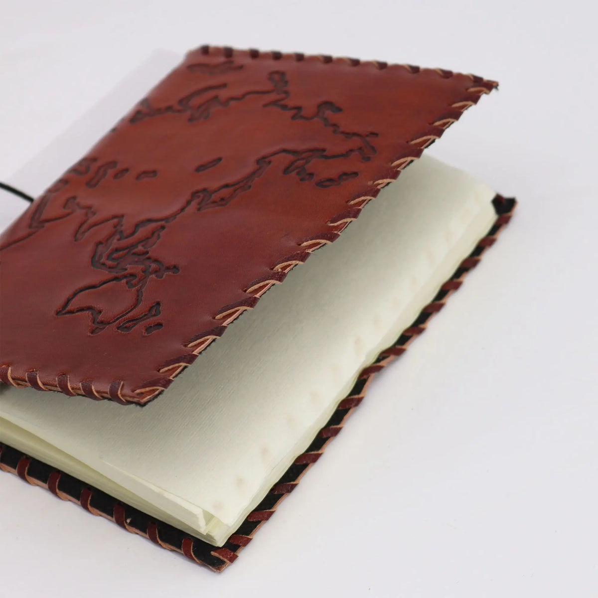 Cuaderno de piel marrón con bordado, páginas en color crema, estilo rústico y artesanal, ideal para escritura.