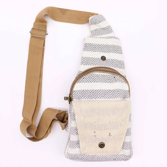 Bolso bandolera de algodón con diseño de espiga gris y blanco, bolsillo frontal beige y correa ajustable color arena.