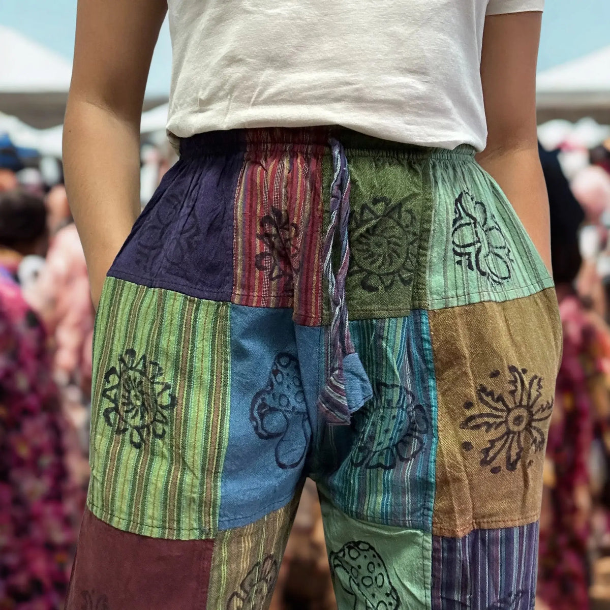 Pantalón estilo nómada, patchwork de telas estampadas en bloques con motivos de hongos en tonos verdes, azul y morado.