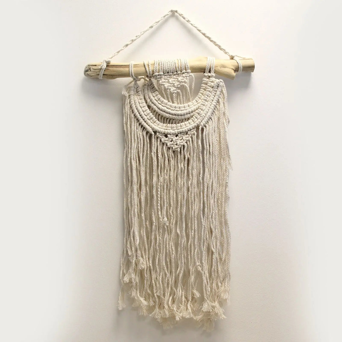 Tapiz de macramé beige con flecos, colgado en una barra de madera. Decoración bohemia para paredes.