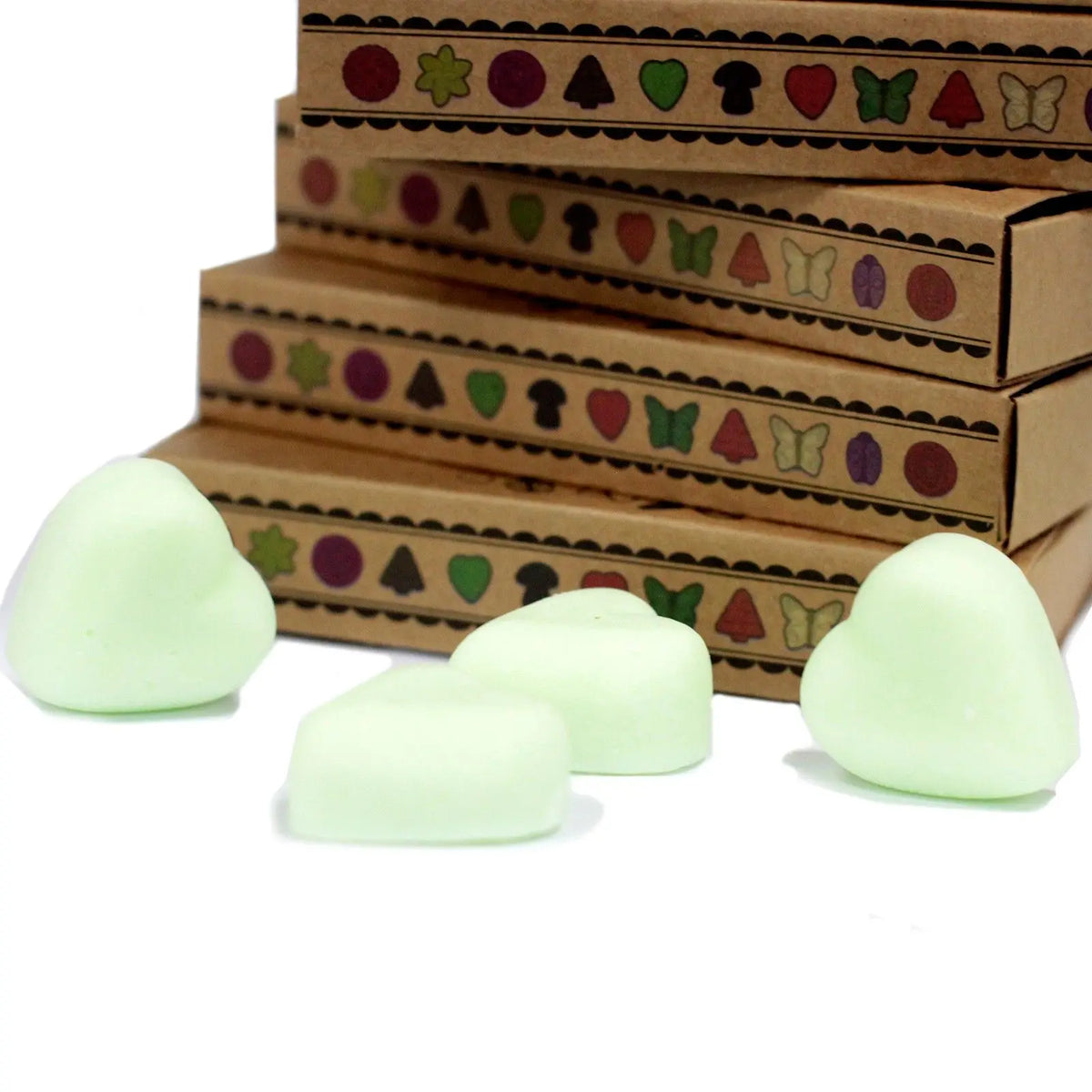 Cajas de cartón kraft con iconos decorativos y ceras de soja en forma de corazón de color verde claro.