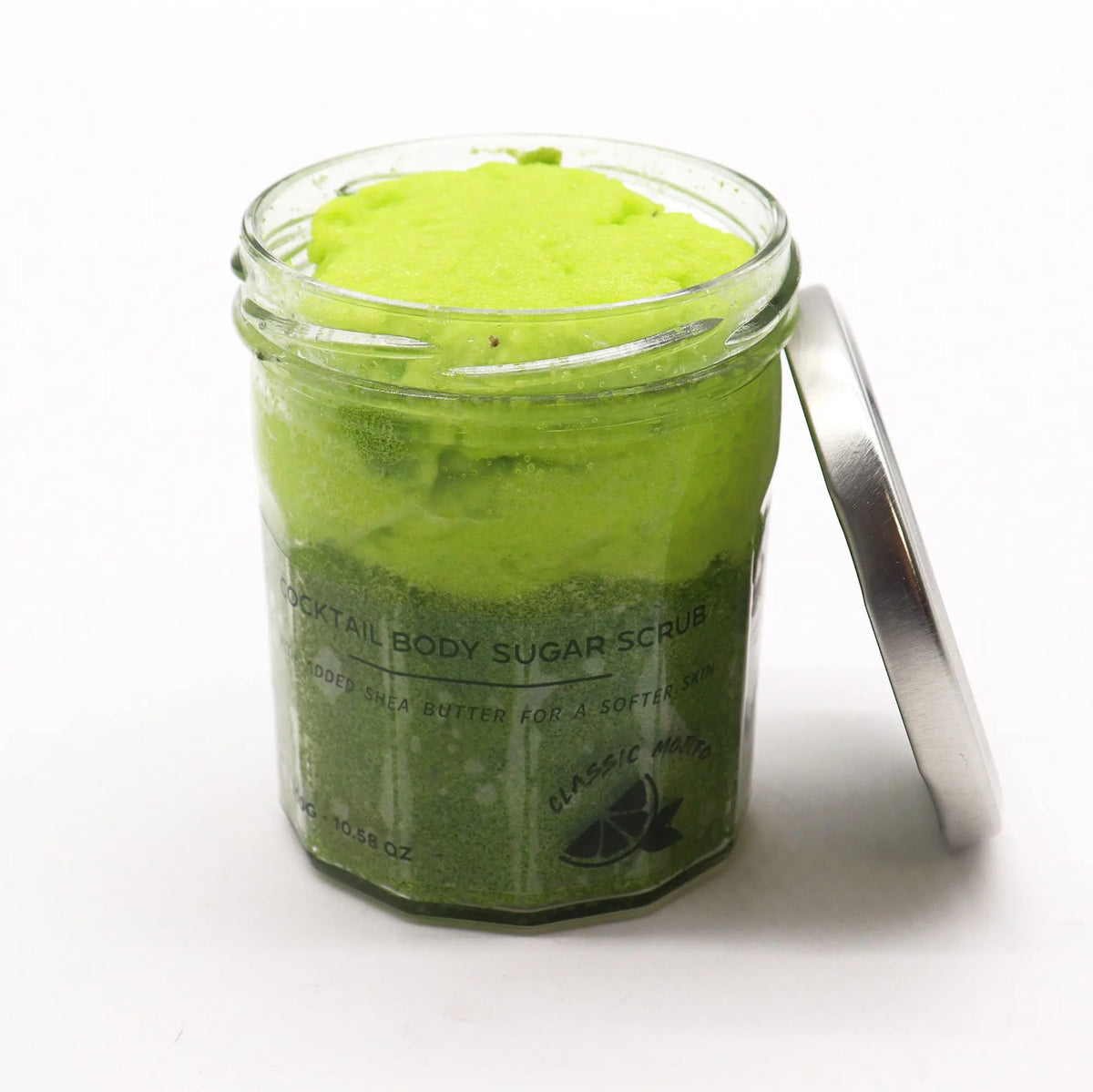 Tarro de vidrio con exfoliante corporal de azúcar color verde brillante y tapa metálica, sobre fondo blanco.