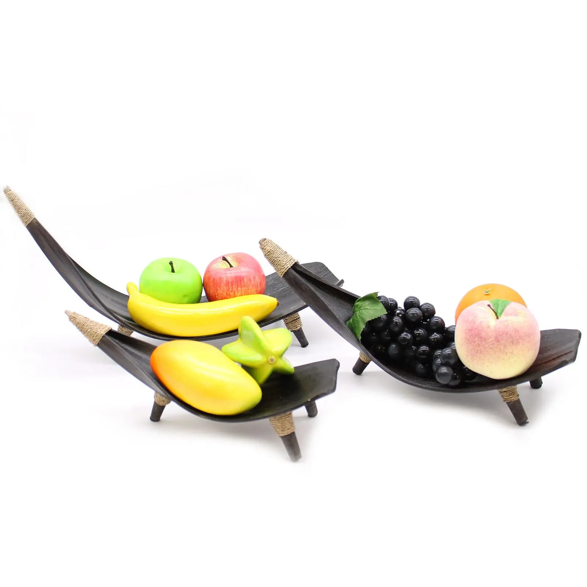 Set de tres fruteros de hoja de coco color chocolate con detalles de cuerda, exhibiendo diversas frutas artificiales.