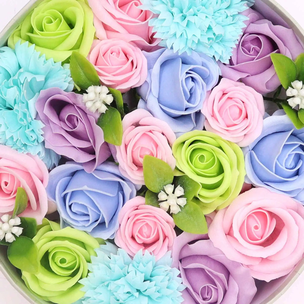 Caja redonda con rosas de jabón en tonos pastel: azul, rosa, lila y verde, decoradas con hojas y flores pequeñas.