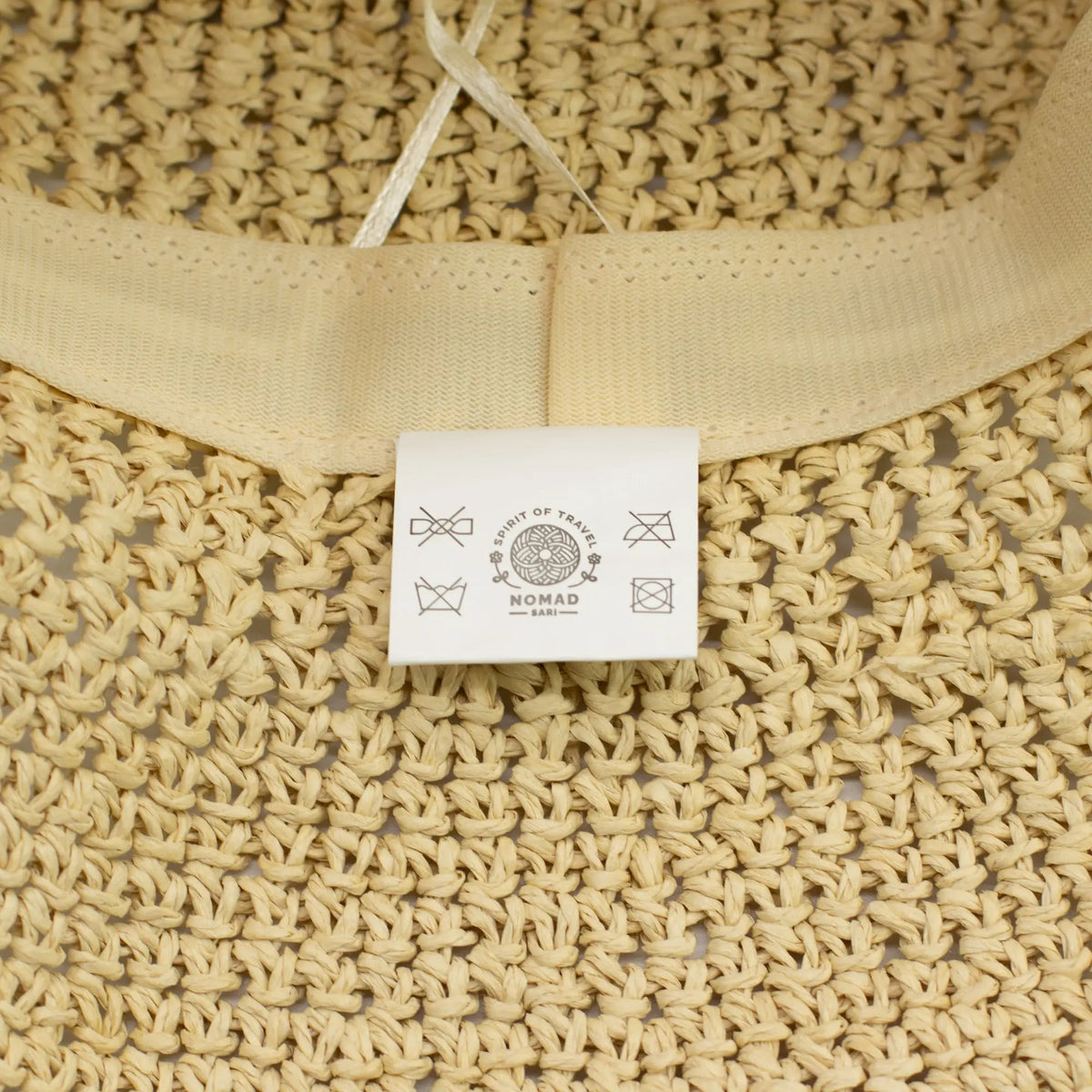 Bolsa de yute color natural con etiqueta blanca, estilo bohemio, ideal para usar en verano.