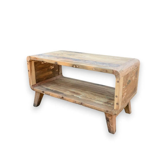 Mesa de centro rectangular de madera reciclada rústica, con estante abierto, esquinas redondeadas y patas cortas.