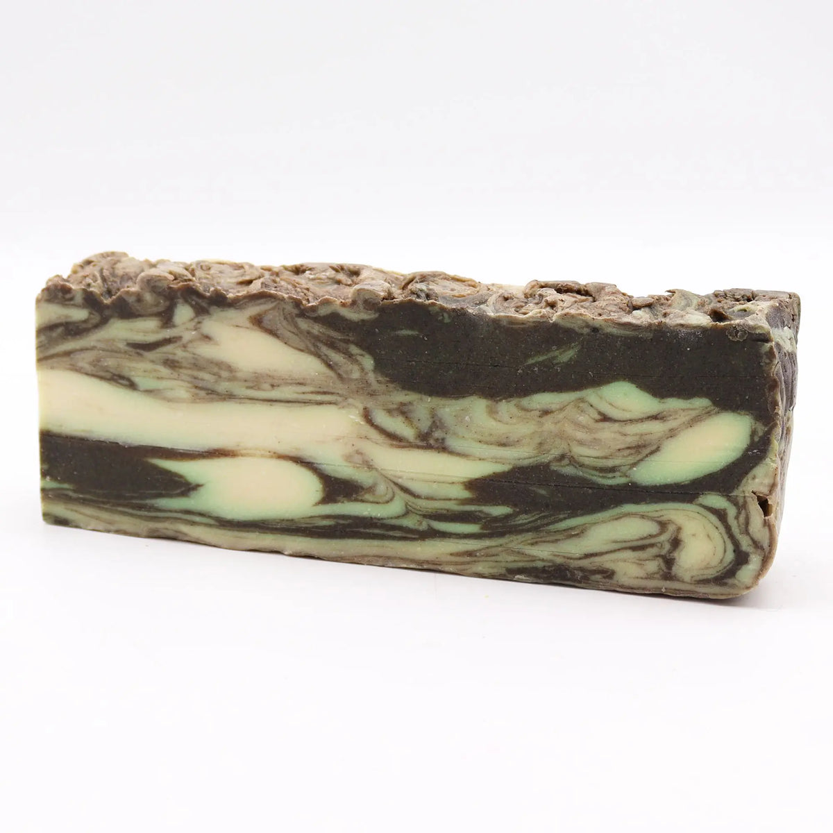 Barra rectangular de jabón artesanal con remolinos de colores café, crema y verde sobre un fondo blanco.