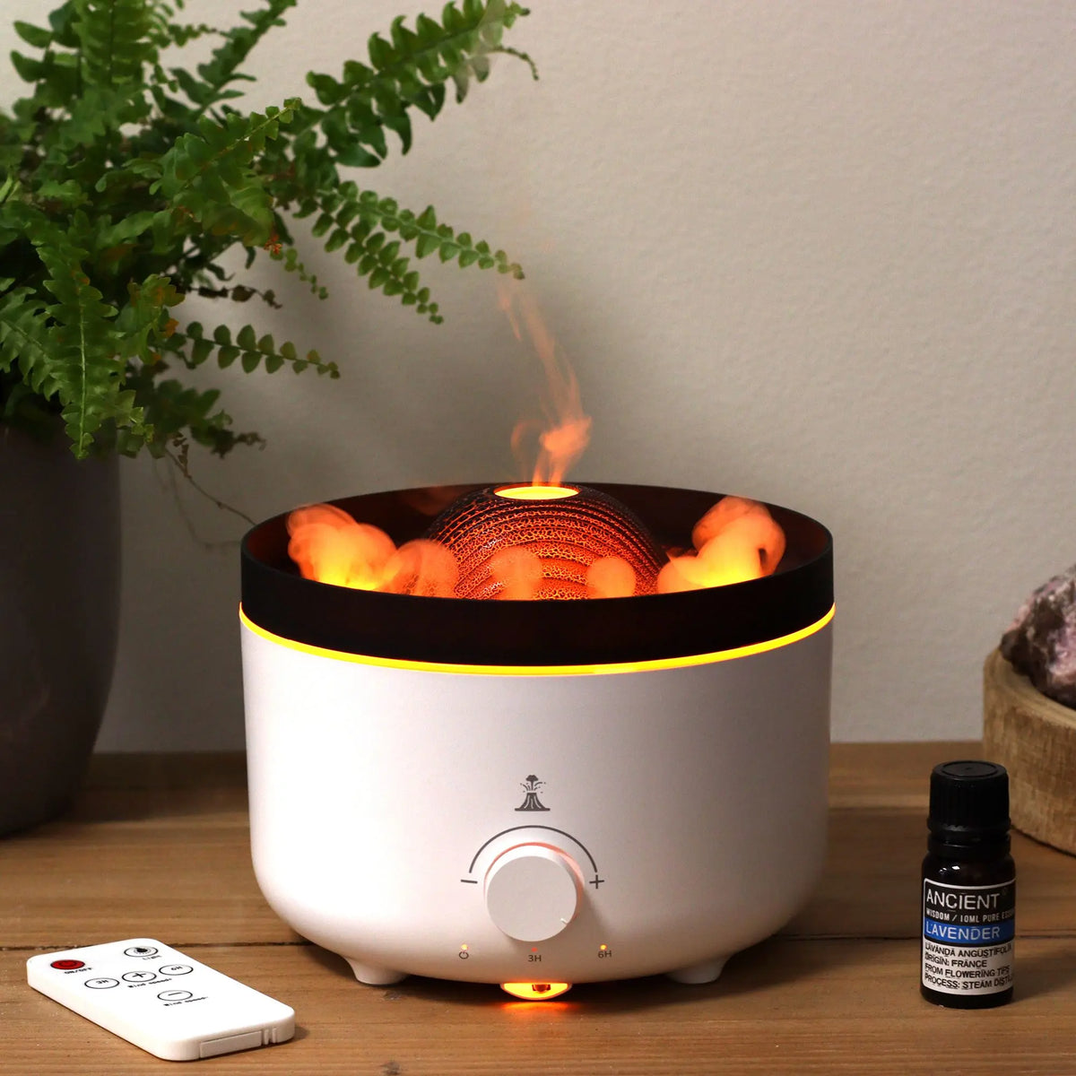 Difusor de aroma eléctrico Ancient Wisdom con efecto volcán, luz naranja cálida, mando a distancia y frasco de esencia.