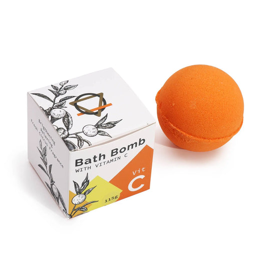 Bomba de baño esférica naranja junto a su caja cuadrada blanca con diseño botánico y etiqueta de Vitamina C.