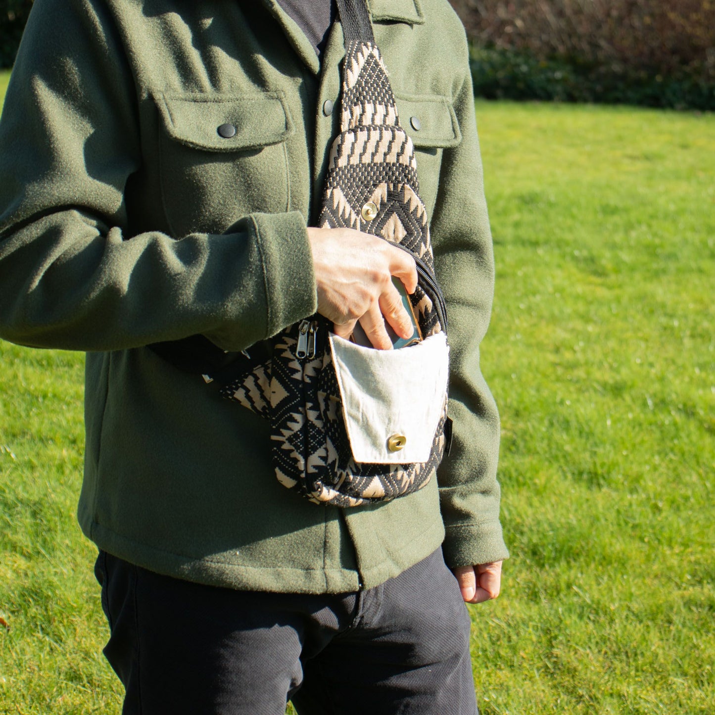Bolso cruzado negro y beige de algodón con estampado tribal, ideal para un estilo casual.
