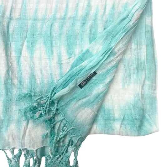 Estola bohemia de lino y rayón con rayas tie-dye turquesa y blancas, textura de cuadros y flecos en los extremos.