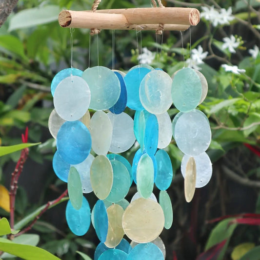 Carillón decorativo con discos circulares de nácar en tonos azules y perla, colgados de una estructura de madera natural.