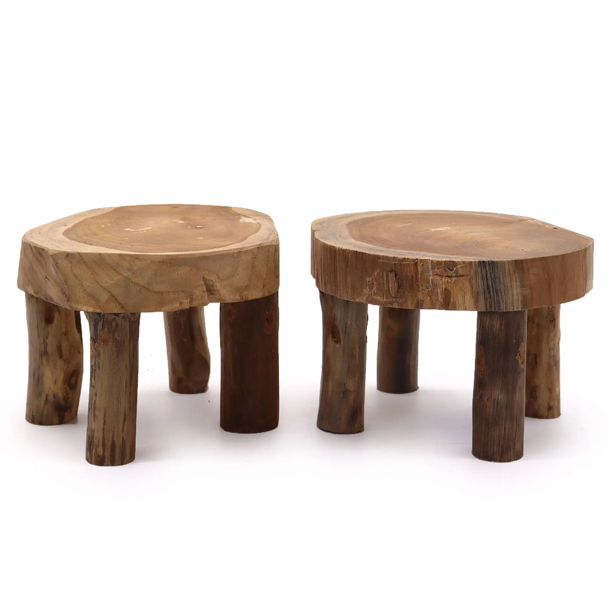 Set de dos exhibidores de madera de teca natural con forma de rodaja de tronco y cuatro patas rústicas. Fondo blanco.