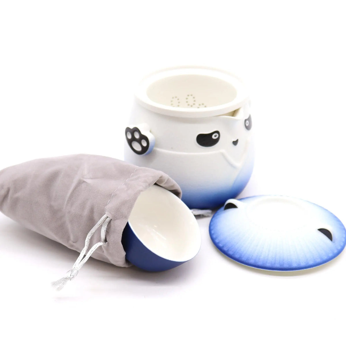 Juego de té de cerámica con diseño de panda, tetera azul y blanca con filtro y una taza en bolsa de tela gris.