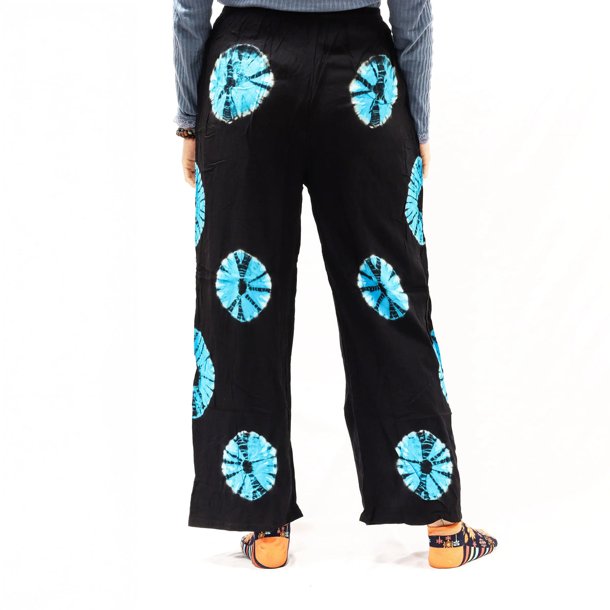 Pantalones de descanso Ancient Wisdom negros con círculos tie-dye azules, corte holgado y cintura elástica.