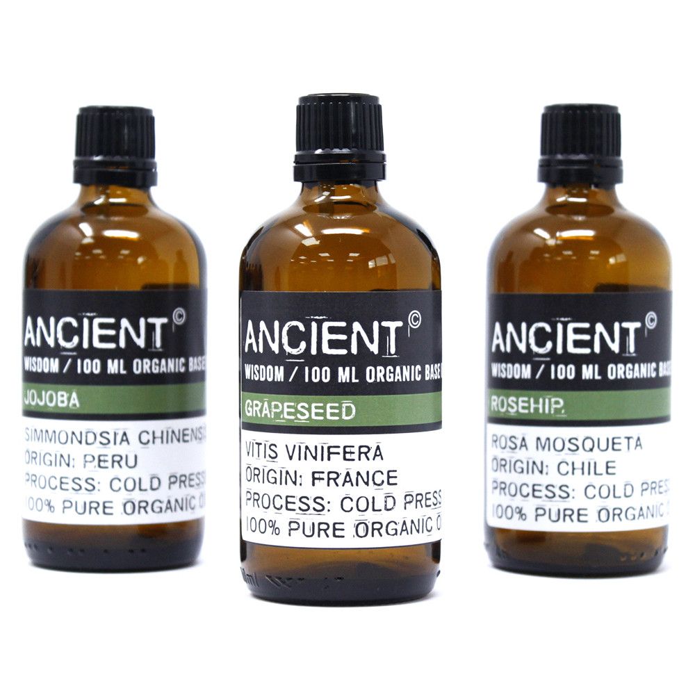 Tres frascos de vidrio ámbar de 100ml con etiquetas informativas sobre aceites base orgánicos de prensado en frío
