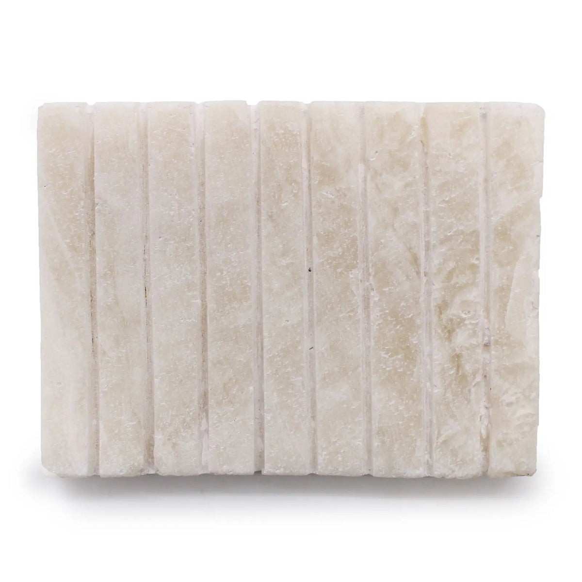 Jabonera rectangular de ónix blanco Ancient Wisdom, hecha en piedra natural con superficie ranurada y acabado artesanal.