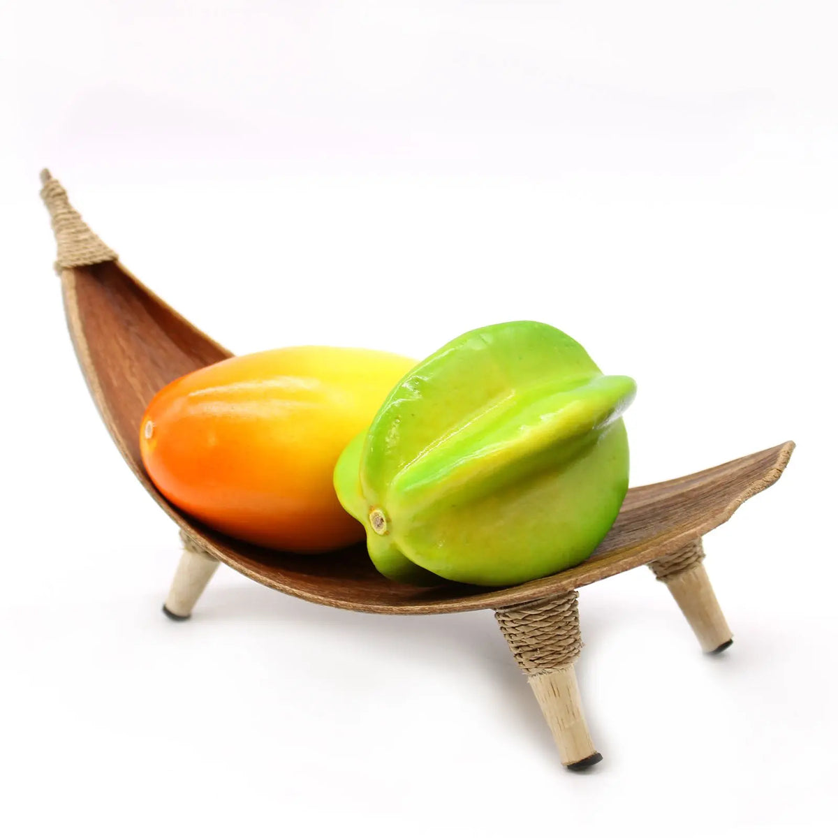 Frutero artesanal de hoja de coco natural con forma de hamaca, decorado con frutas decorativas sobre fondo blanco.