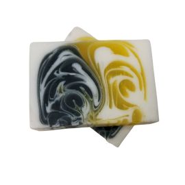 Dos pastillas de jabón artesanal rectangular con diseño marmolado en tonos amarillo, negro y blanco sobre fondo blanco.