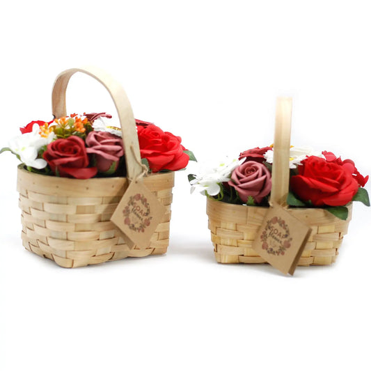 Dos cestas de mimbre con arreglos de flores de jabón rojas y blancas, decoradas con etiquetas de cartón.