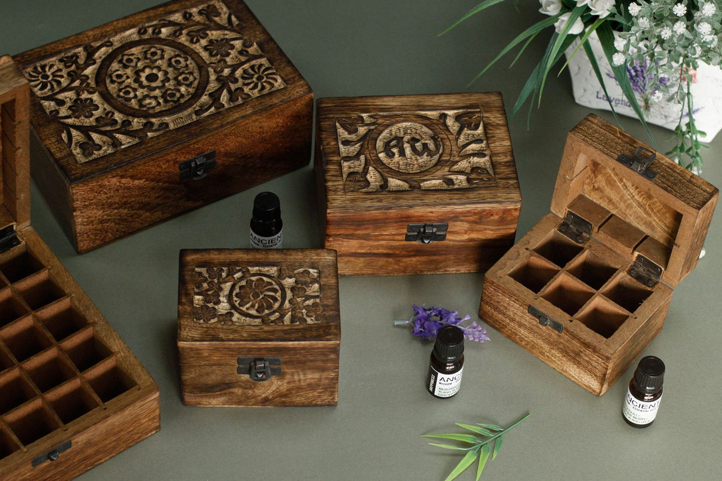 Cajas de madera de mango talladas, de color marrón oscuro, con compartimentos internos para aceites esenciales.