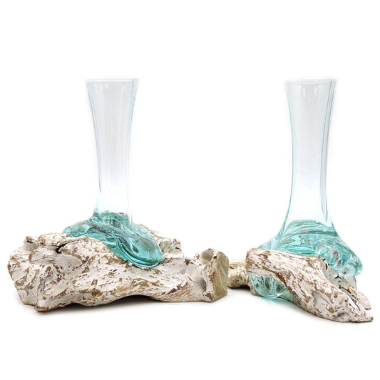 Dos floreros artesanales de vidrio fundido transparente con base de madera natural blanqueada y estilo rústico.