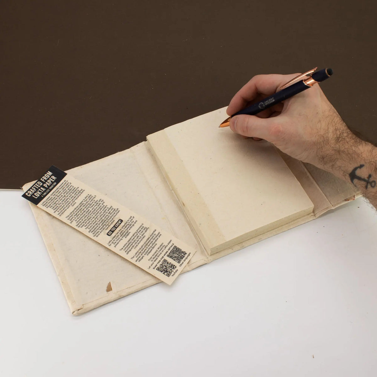 Cuaderno de papel reciclado en color crema con marcador, cubierta de tela beige, estilo artesanal y ecológico.