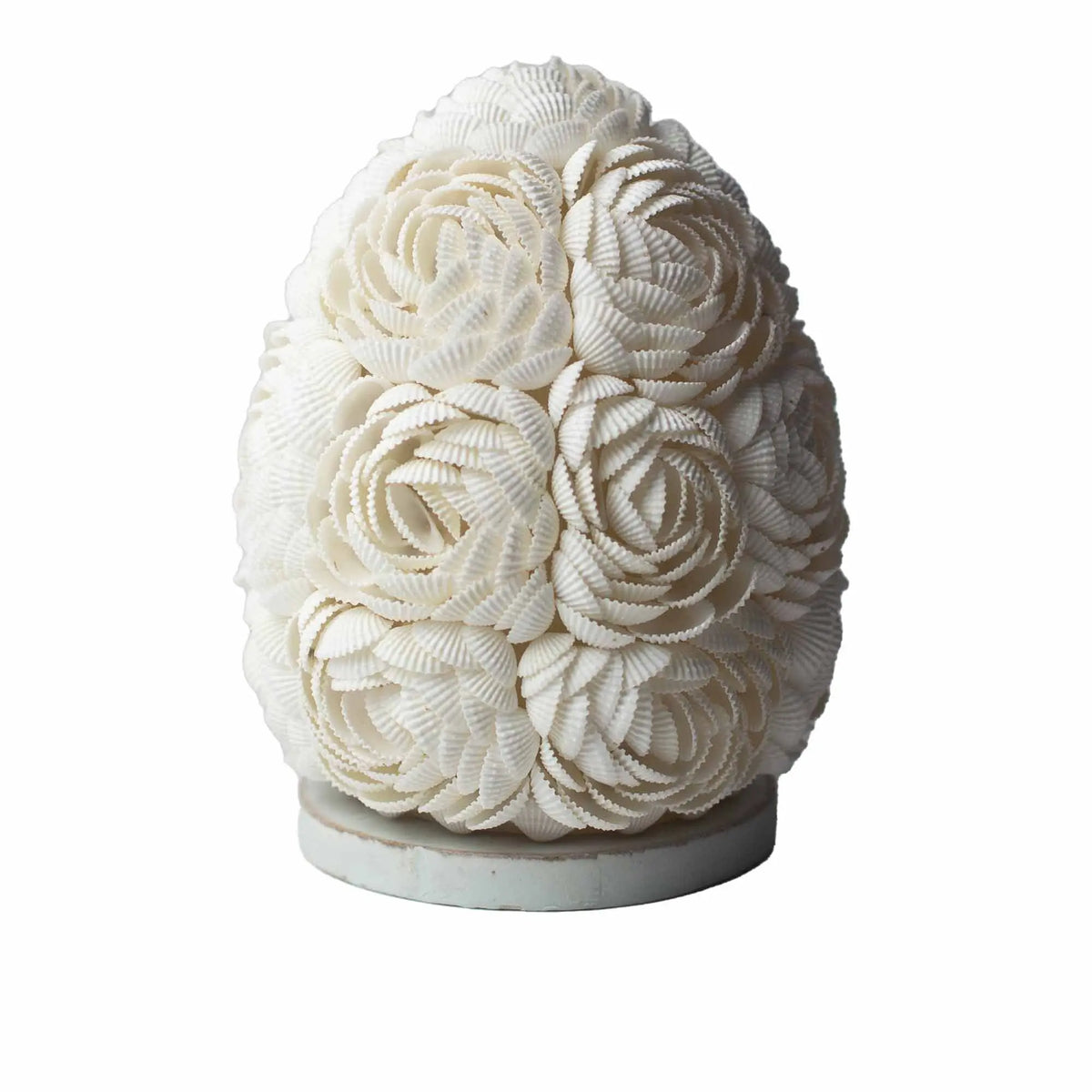 Lámpara boho ovalada de 15cm hecha a mano con pequeñas conchas blancas dispuestas en forma de flores sobre una base.
