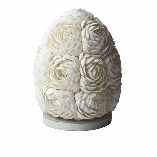 Lámpara boho ovalada de 15cm hecha a mano con pequeñas conchas blancas dispuestas en forma de flores sobre una base.