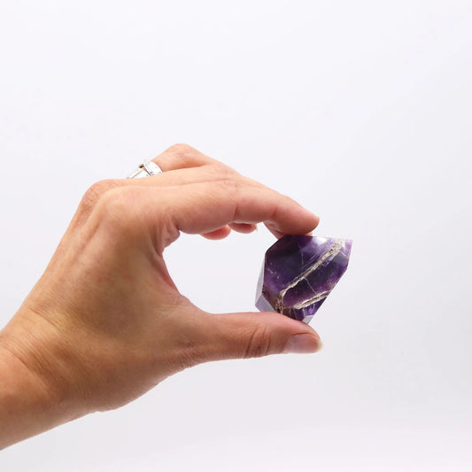 Cristal de amatista morado con veta dorada, corte elegante, ideal para decoración o colección.