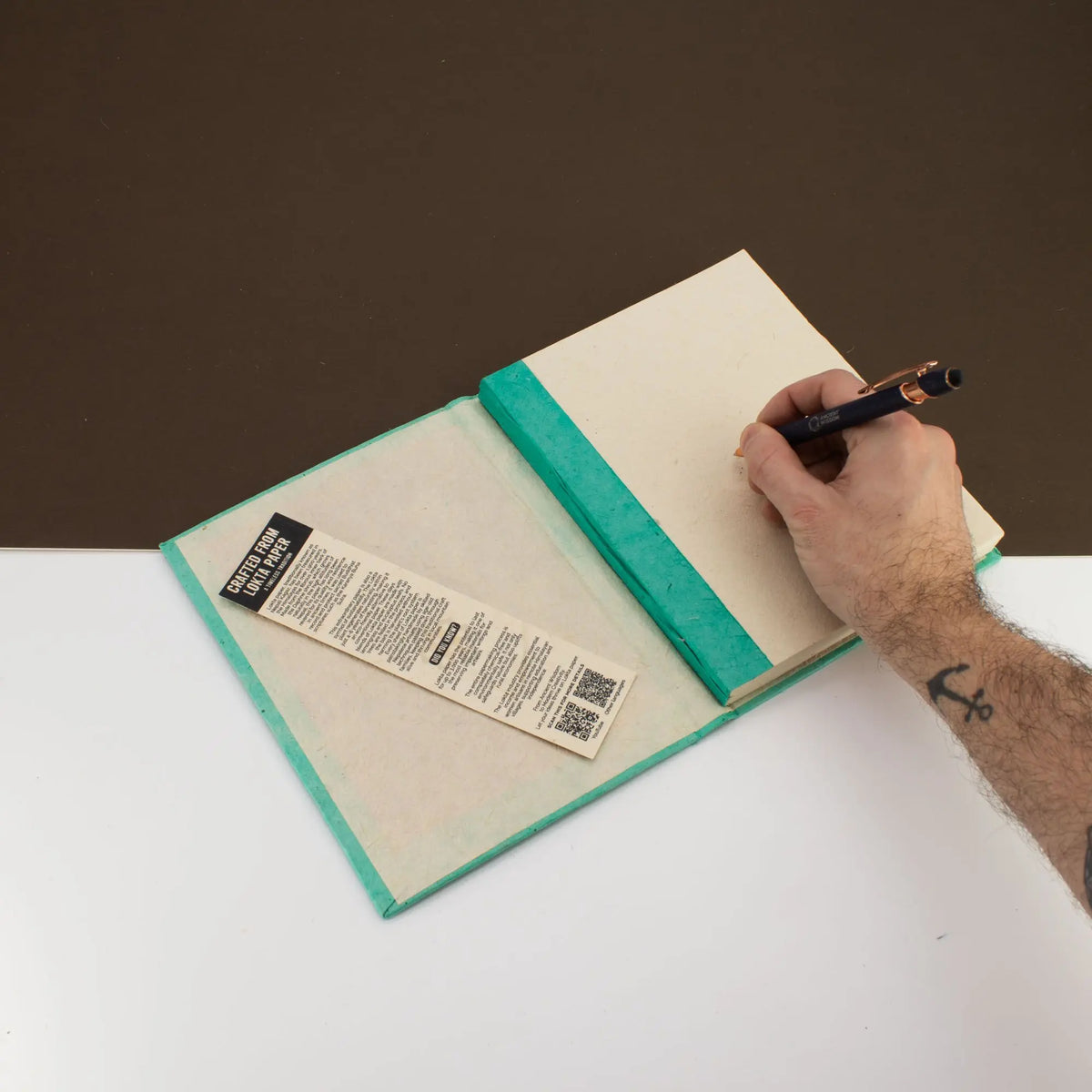 Cuaderno reciclado con tapa verde y papel sin líneas, ideal para escribir y dibujar.