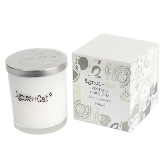 Vela de soja "Vintage Gardenia" de Agnes + Cat, color blanco, en frasco de vidrio con tapa plateada y caja decorativa.