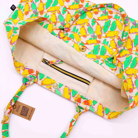 Bolso de tela grande con estampado de peces koi en tonos amarillos y verdes, con cierre de broche y bolsillo interno.