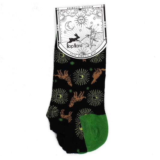 Calcetines negros con estampado de ciervos y soles en tonos marrón y verde, material cómodo y estilo casual.