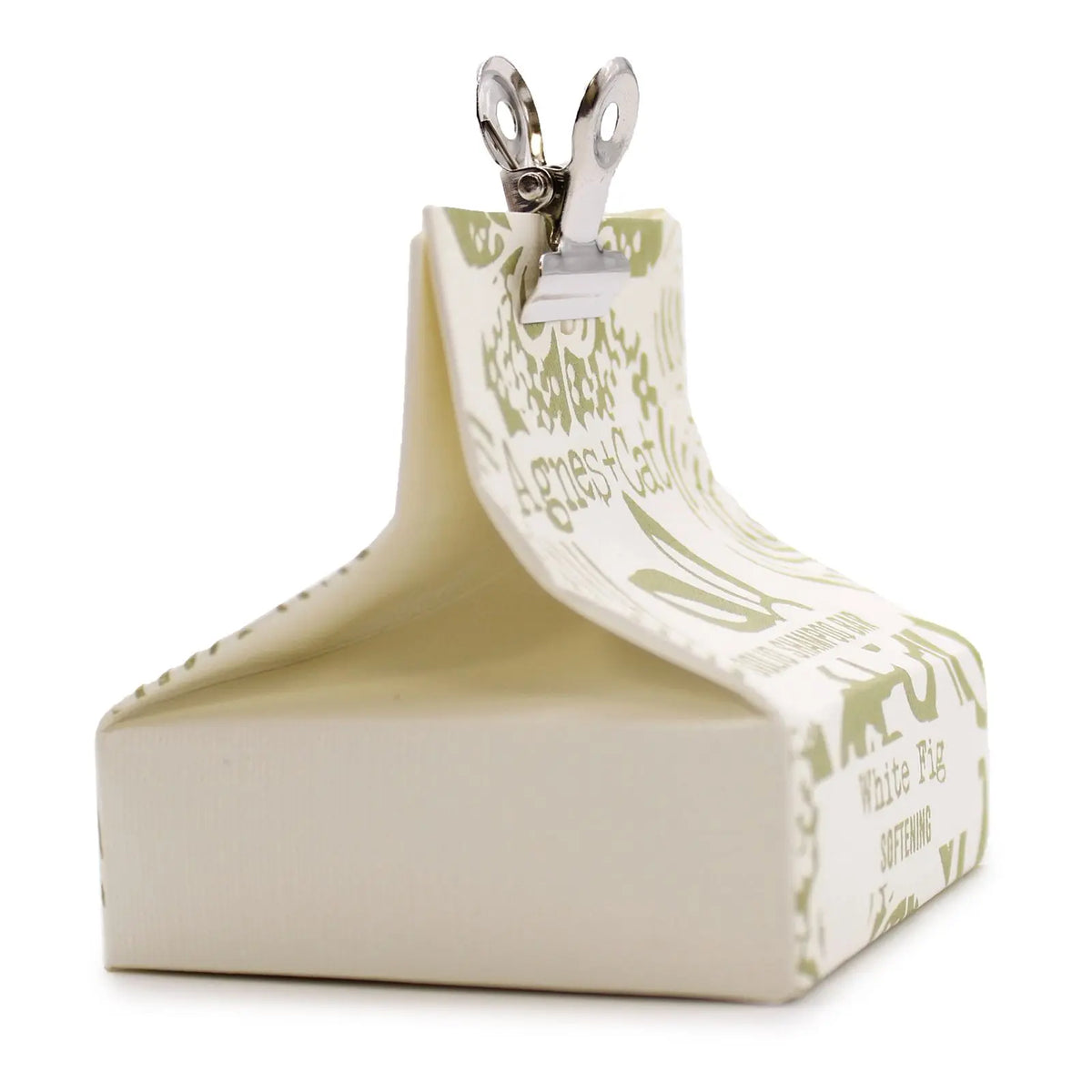 Caja de cartón color crema con detalles en verde y pinza metálica, contiene champú sólido de higo Agnes + Cat.