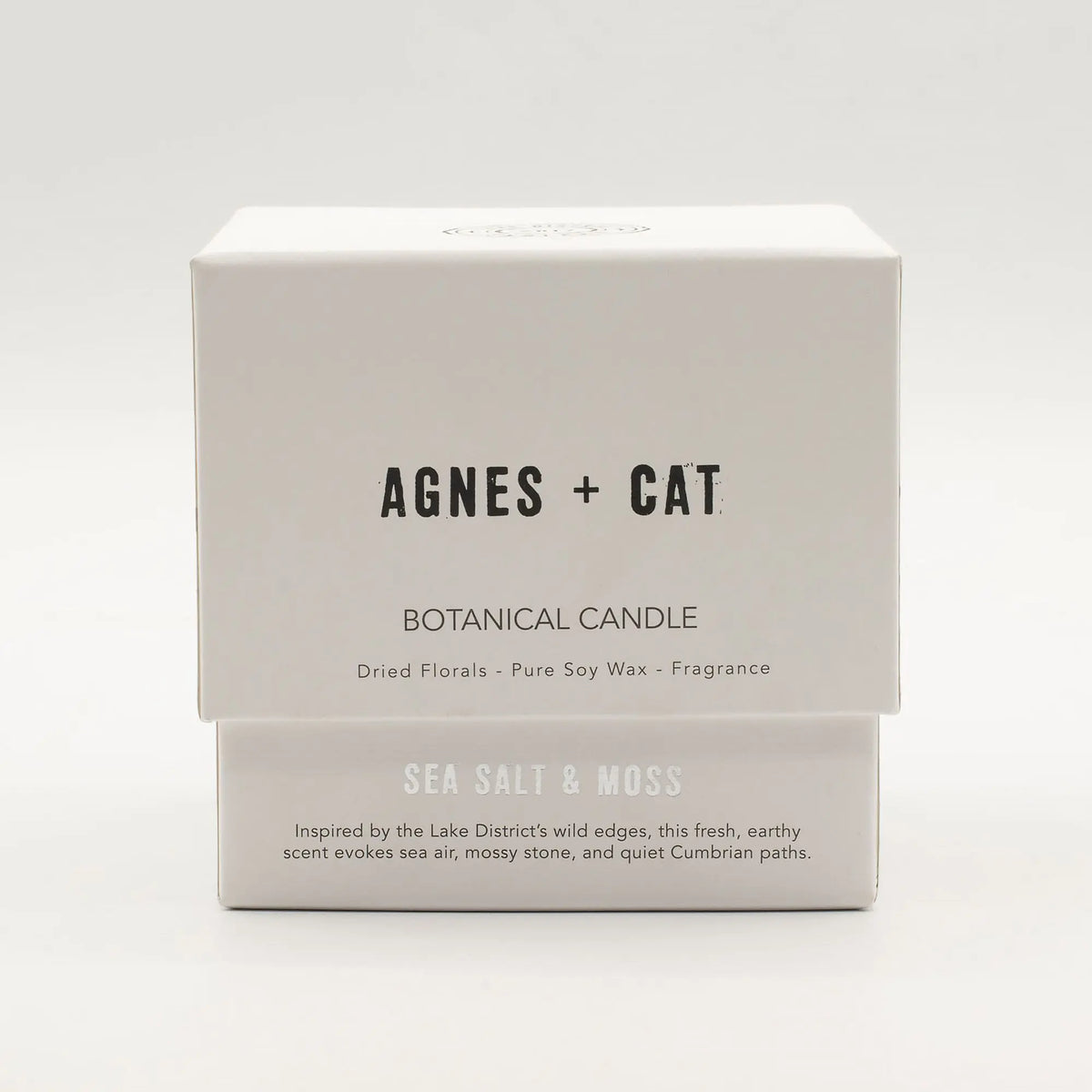 Vela botánica Agnes + Cat, cera de soja, fragancia sal marina y musgo, caja blanca con diseño minimalista.