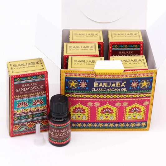 Frasco de aceite esencial y cajas con diseño estampado colorido de estilo hindú sobre fondo blanco.