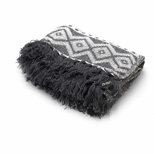 Manta de algodón gris y negro con diseño geométrico y flecos, ideal para decoración y confort.